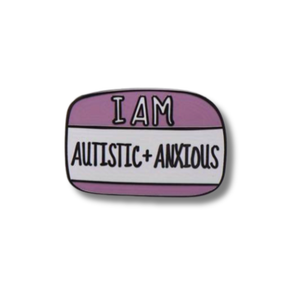 Enamel pin with 'I AM AUTISTIC + ANXIOUS' text on a white background