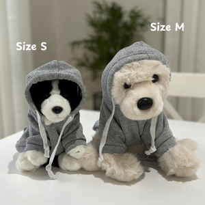 Two stuffed animals in gray hoodies labeled 'Size S' and 'Size M' on a white surface.