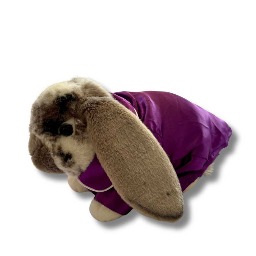 A plush rabbit wearing purple pyjamas