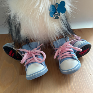 Blue baby shoes with pink laces on a wooden floor