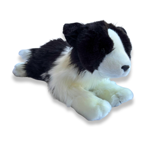 Plush toy of a black and white dog on a white background