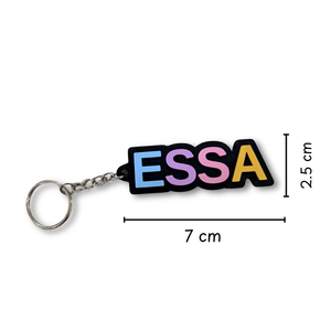 A colorful lettered keychain spelling 'ESSA' with a silver split ring and chain, shown on a white background with dimension lines indicating 7 cm width and 2.5 cm height.