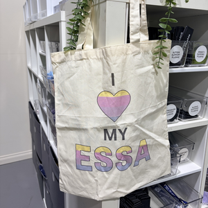 Tote bag with 'I ❤️ MY ESSA' text hanging on a shelf.