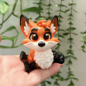 Small fox figurine held in a hand with a green leafy background