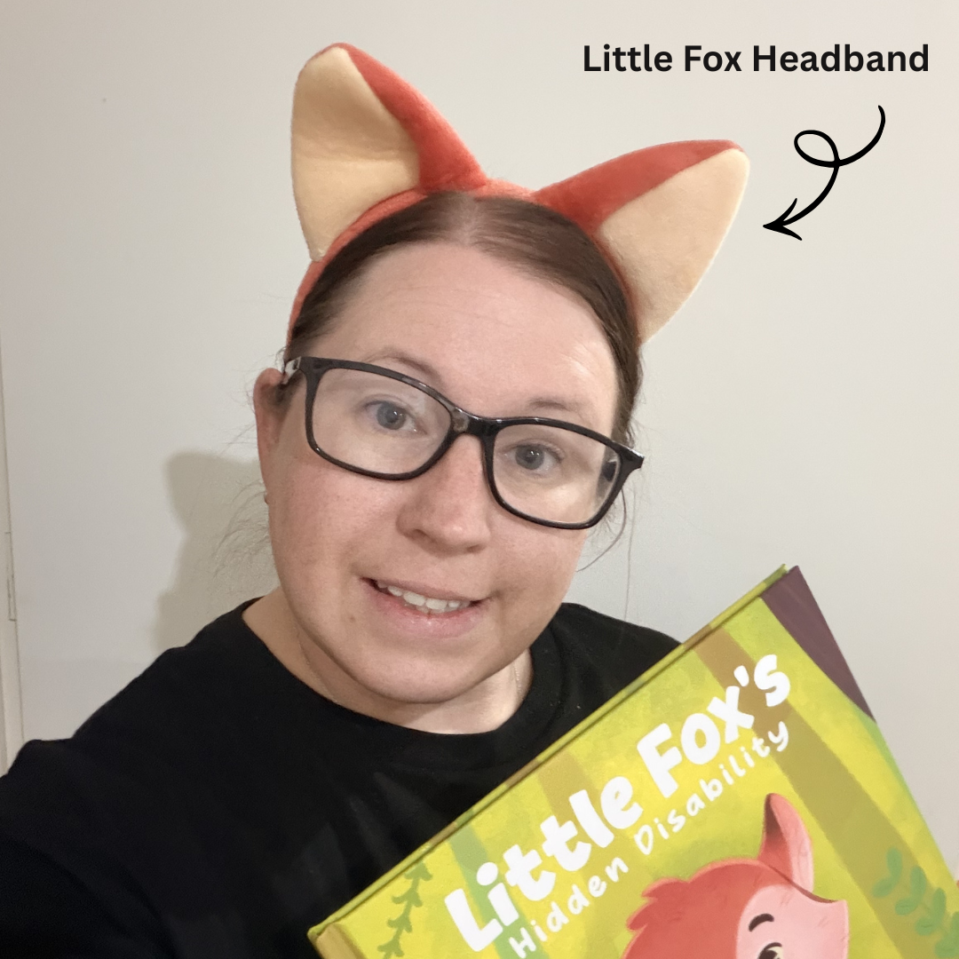 Person wearing a fox headband holding a book titled 'Little Fox's Hidden Disability'.