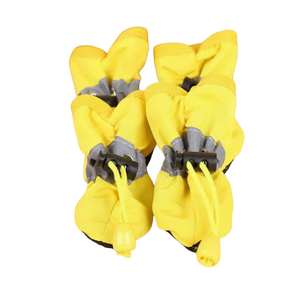 Pair of yellow dog boots with gray straps on a white background