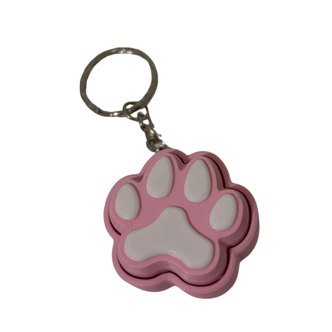 Pink paw-shaped keychain on a white background