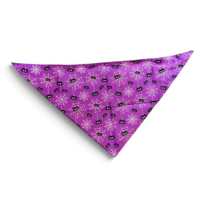 A purple triangular pet bandana featuring a repeating pattern of white spiderwebs and small black spiders, displayed on a clean white background.