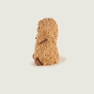A small plush toy shaped like a hedgehog or porcupine, shown from the back on a plain light gray studio background.