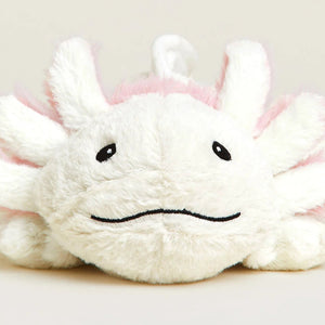 A white plush toy with pink accents and embroidered black facial features, photographed against a plain light beige background.