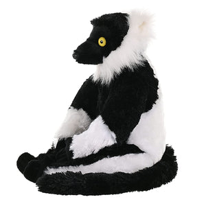 A plush toy lemur sitting upright, featuring black and white fur with a yellow eye, isolated on a white background.
