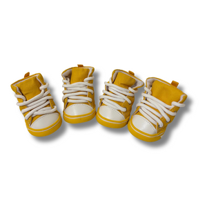 Four pairs of yellow high-top sneakers with white laces on a white background
