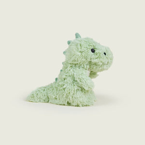 A light mint green plush dinosaur toy with small black bead eyes, photographed on a clean, solid, warm off-white background.