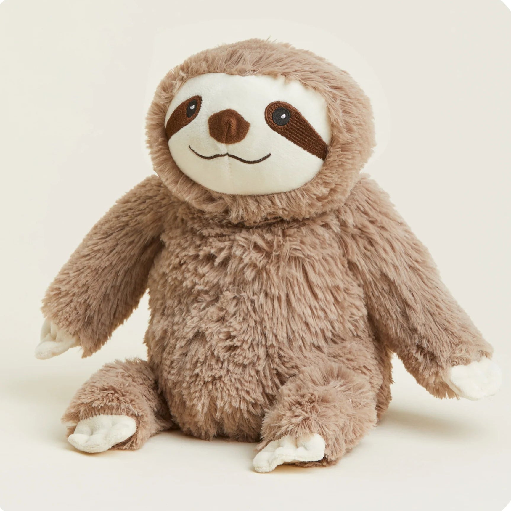 Plush toy sloth on a light beige background