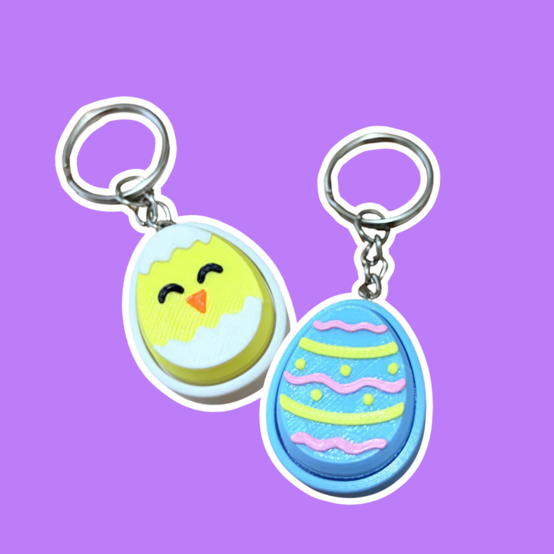 Two Easter themed fidget clicker keychains on a purple background.