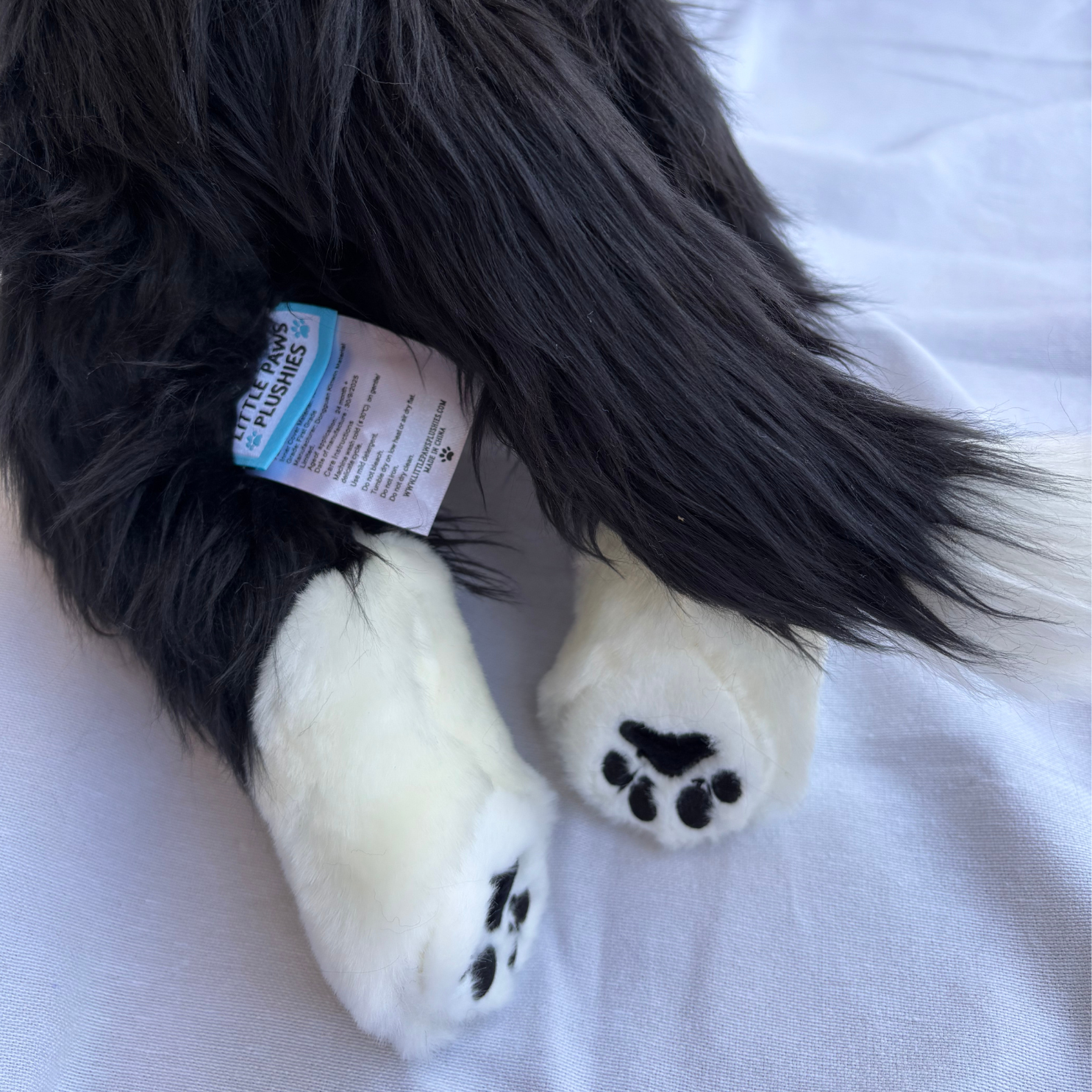 Black and white dog toy with paw prints on a white surface