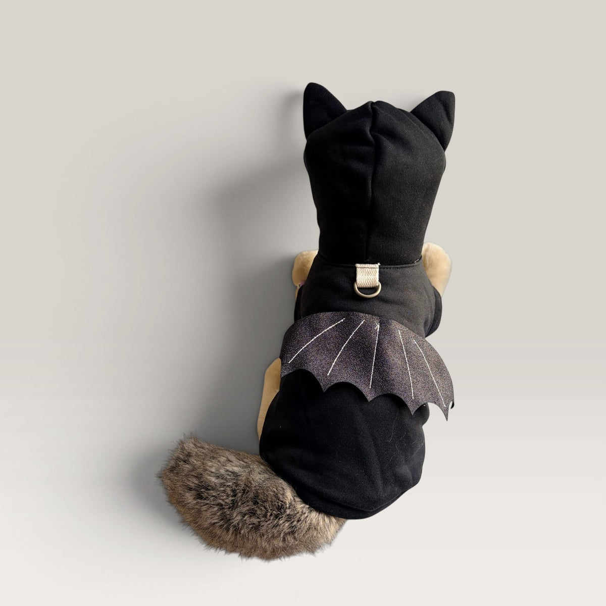 Black Pet hoodie costume for halloween with bat wings on a plushie dog on a white background.