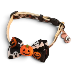 A pet collar with a Halloween-themed bow featuring black and white ghosts, orange jack-o'-lanterns, and a small orange pumpkin charm, on a white background.