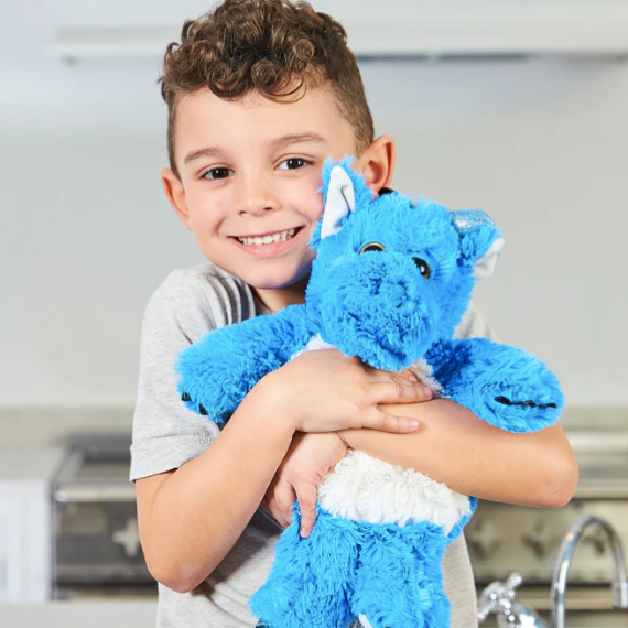 A boy hugging a Blue Dragon - Warmies brand heatbag