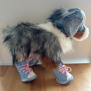 Stuffed animal with fur and shoes on a wooden floor