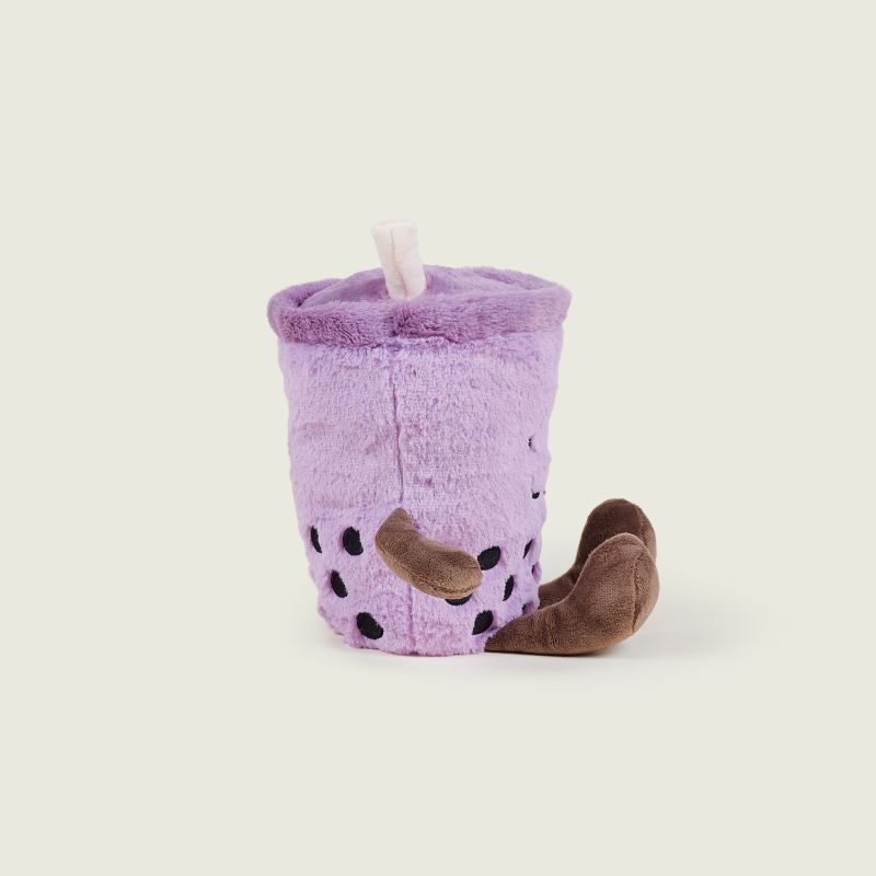A plush toy designed to look like a purple boba tea cup with brown bean accents and a small white straw, photographed on a plain light beige background.