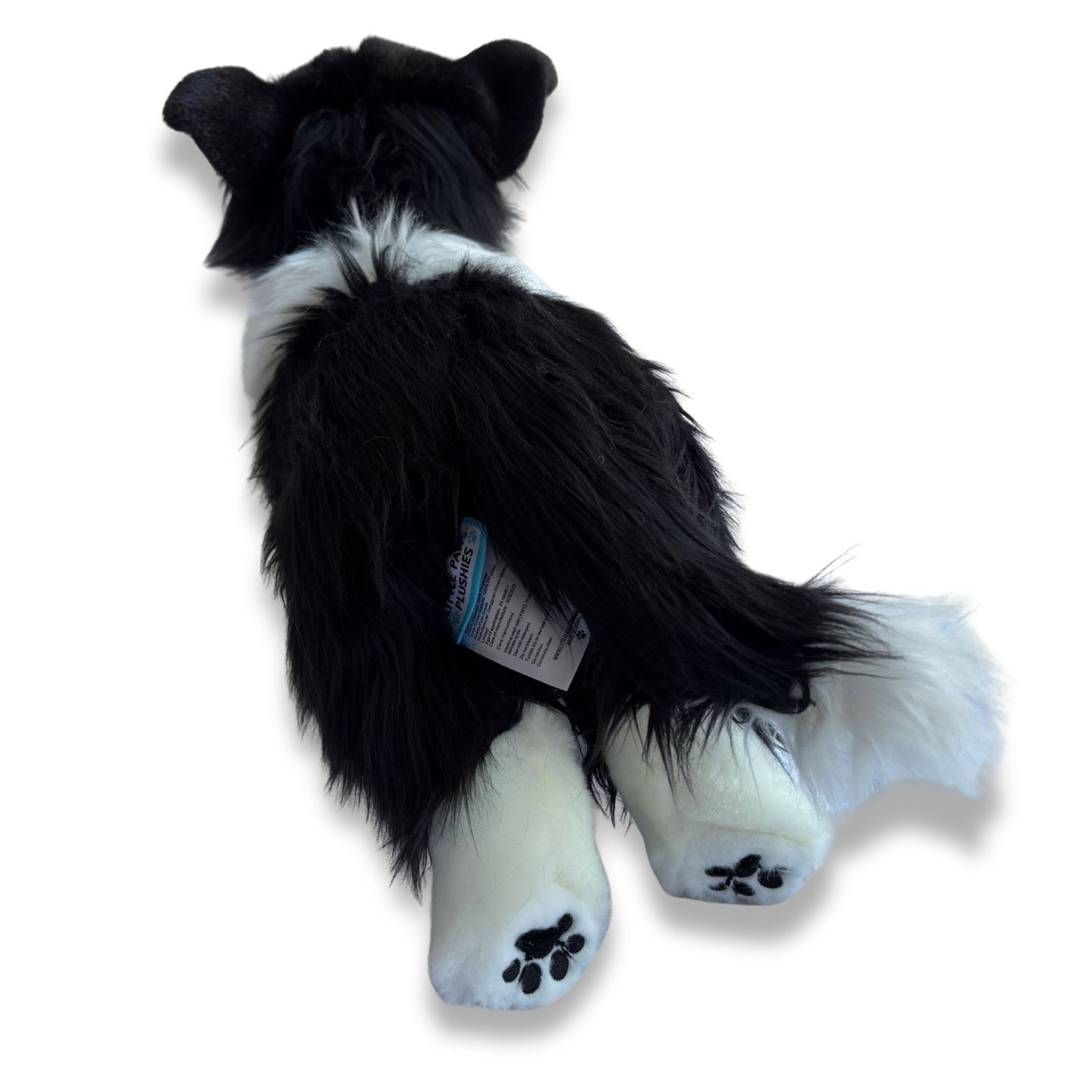 Black and white plush dog toy on a white background