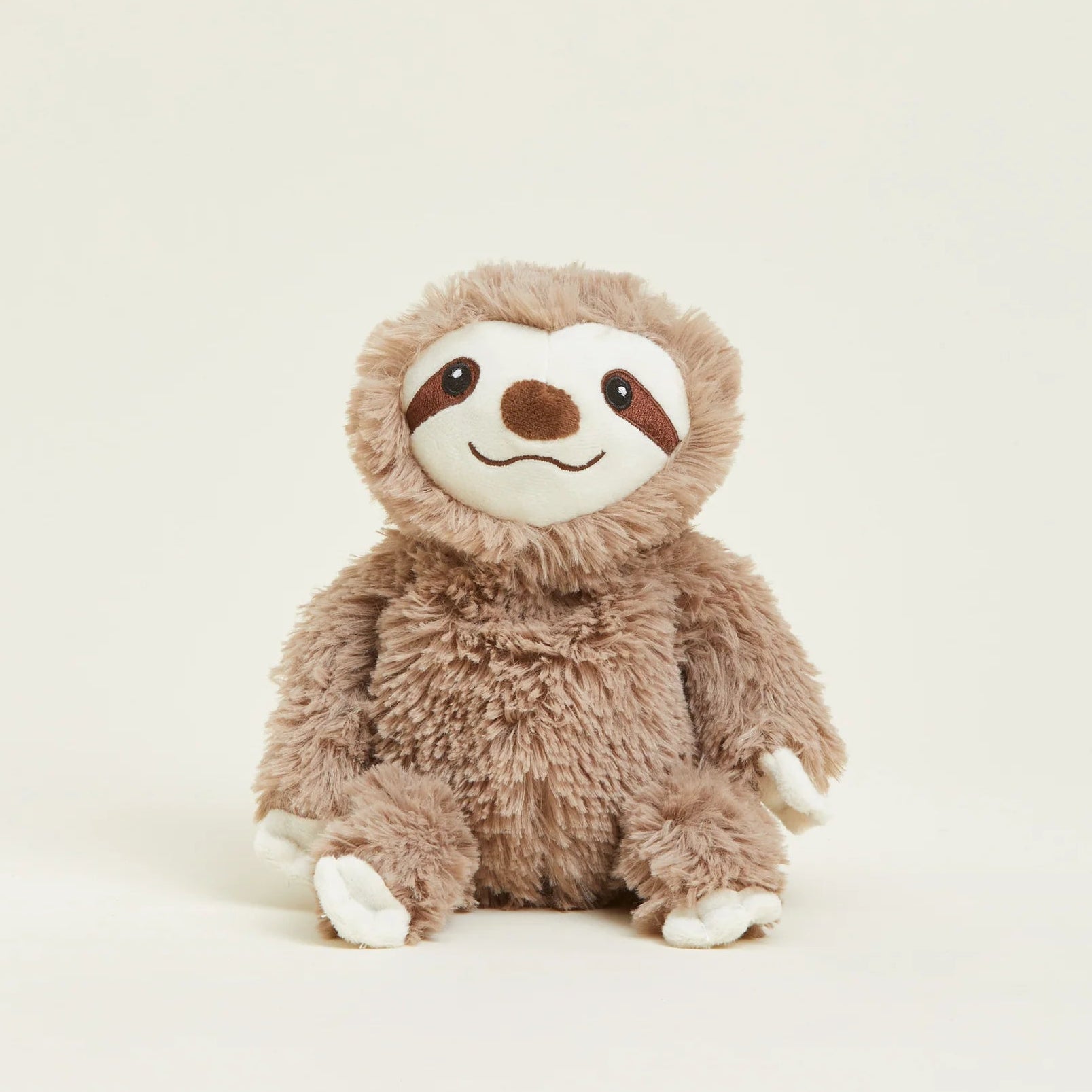 Plush toy sloth on a light beige background