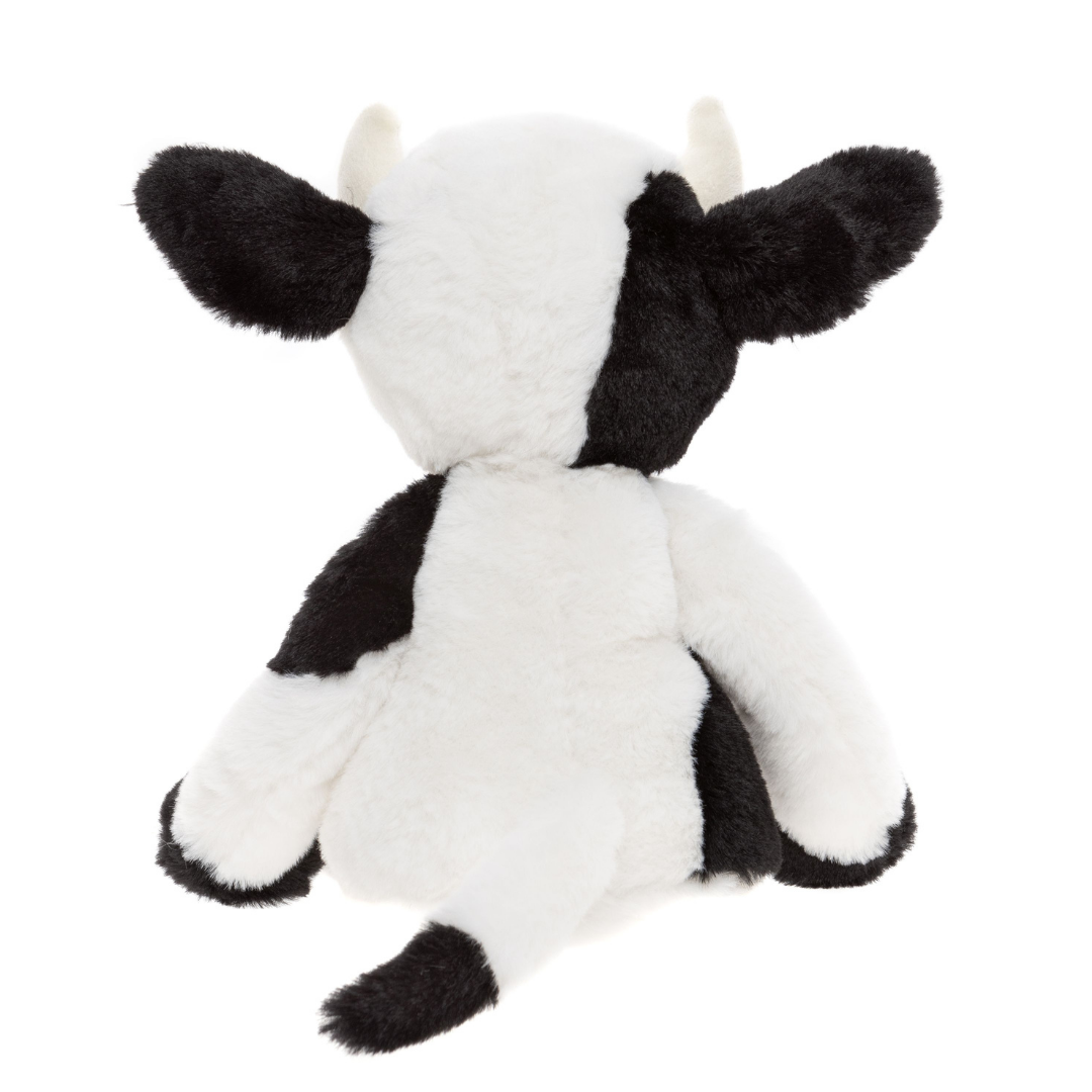 Black and white cow plush toy on a white background