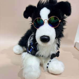 Plush toy dog with sunglasses and a blue collar on a beige background