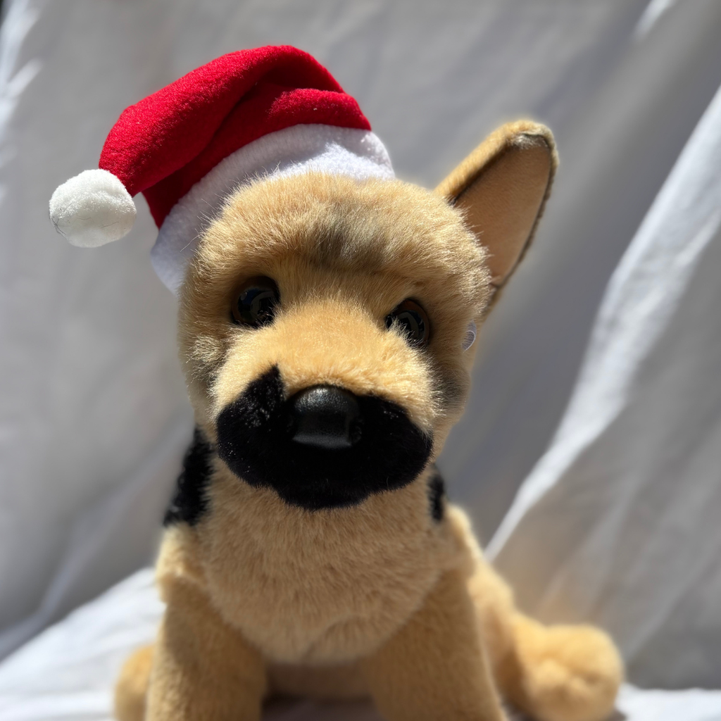 Plush dog toy wearing a red Santa hat on a white background