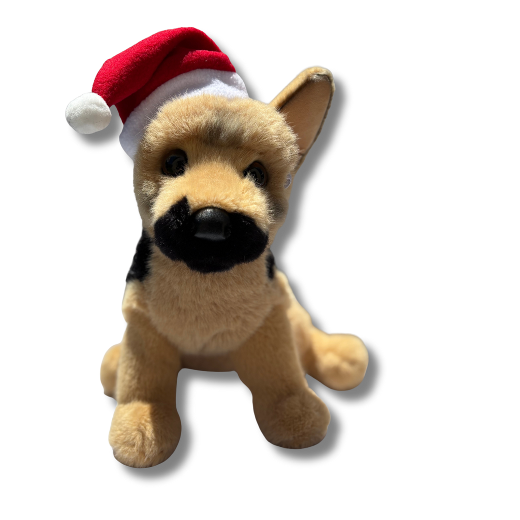 Plush toy German Shepherd dog wearing a red Santa hat on a white background