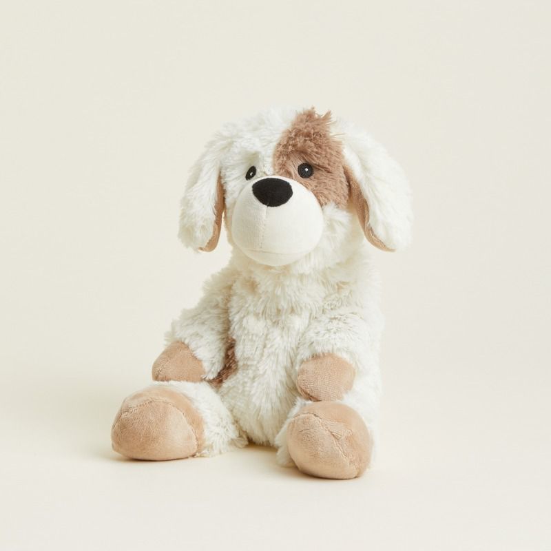 Plush dog toy with white and brown fur on a beige background