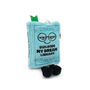 Plush toy book with character design and text 'Building My Dream Library' on a white background