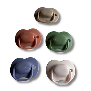 Set of five colorful pacifiers on a white background