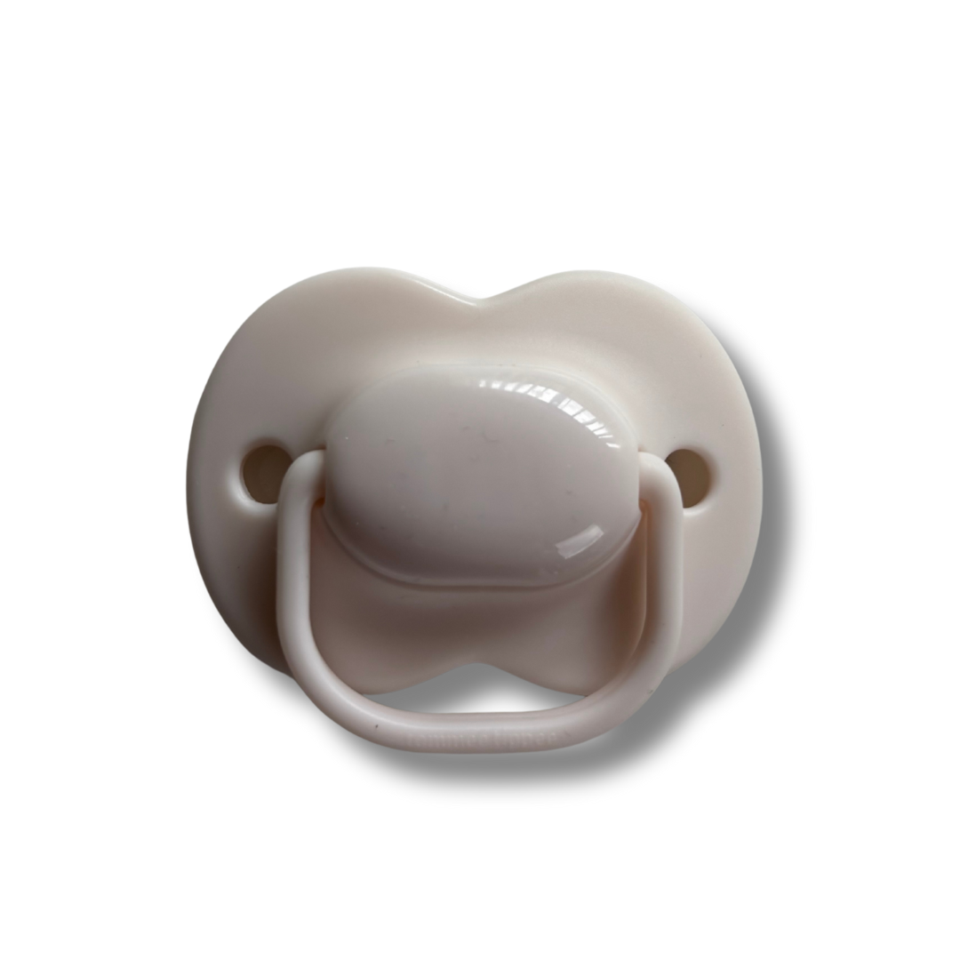 Beige pacifier on a white background