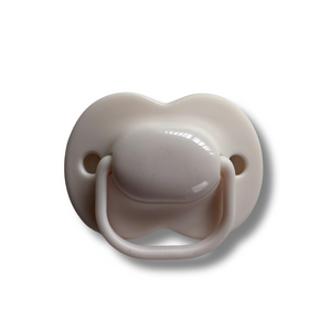 Beige pacifier on a white background