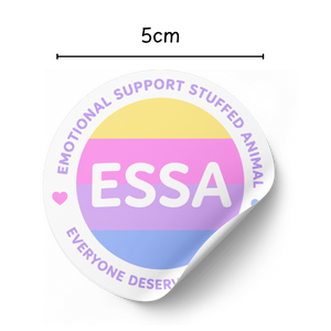 A circular sticker with a peeled-back lower right corner, shown on a white background with a dimension line above indicating 5cm width. The sticker features the text 'ESSA' in white over horizontal pastel stripes in yellow, pink, purple, and blue, with purple text around the border reading 'EMOTIONAL SUPPORT STUFFED ANIMAL' and 'EVERYONE DESERVES'.