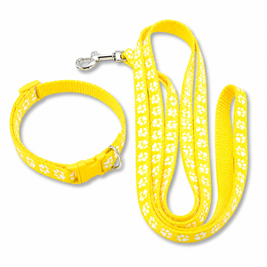 Yellow dog collar and matching leash set with white paw print pattern and silver metal hardware, shown on a plain white background.