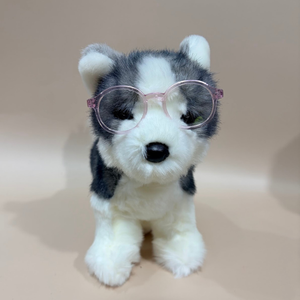 Plush toy husky dog wearing pink glasses on a beige background
