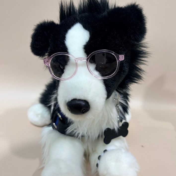 Plush toy dog with glasses on a beige background