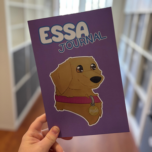 Purple journal with a dog illustration and 'ESSA JOURNAL' text held by a hand.