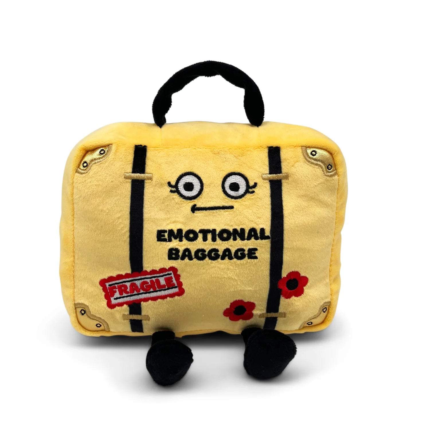 A yellow plush toy shaped like a suitcase with a black handle, black straps, embroidered facial features, the words 'EMOTIONAL BAGGAGE' on the front, a red 'FRAGILE' patch, and small black feet, shown on a white background.