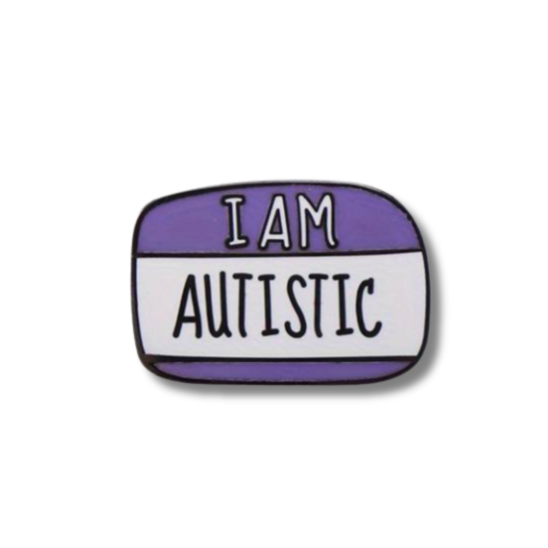 Enamel pin with 'I AM AUTISTIC' text on a white background