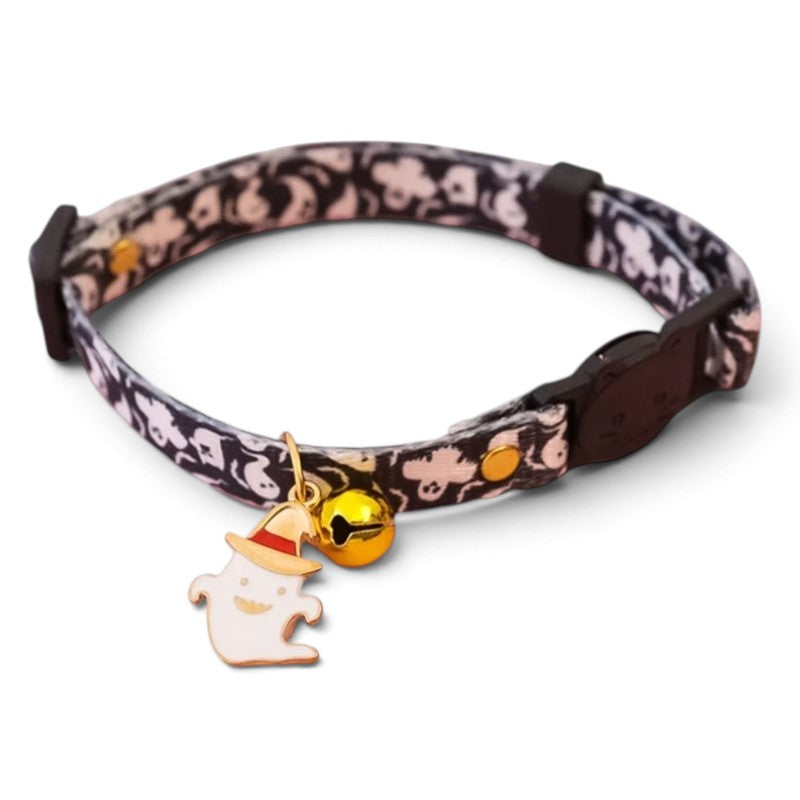 A patterned cat collar with a black and white ghost design, featuring a small gold bell and a ghost charm wearing a gold and red hat.