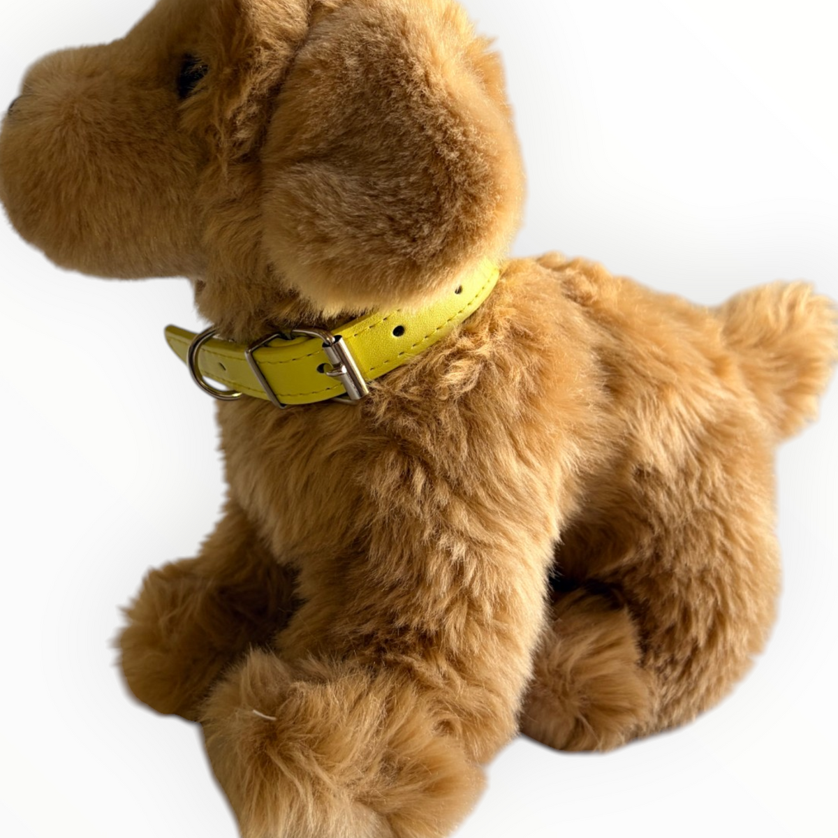 A golden retriever plush toy dog wearing a bright yellow collar, photographed against a plain white background.