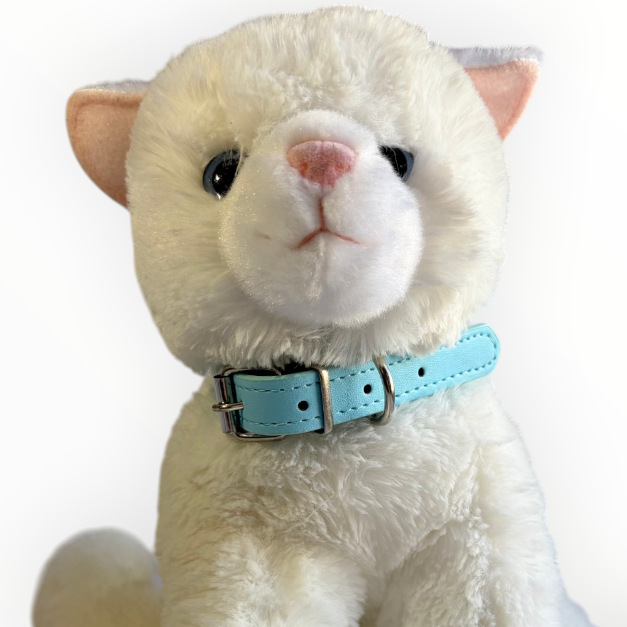 A white plush cat toy wearing a light blue collar with silver metal hardware, photographed against a plain white background.