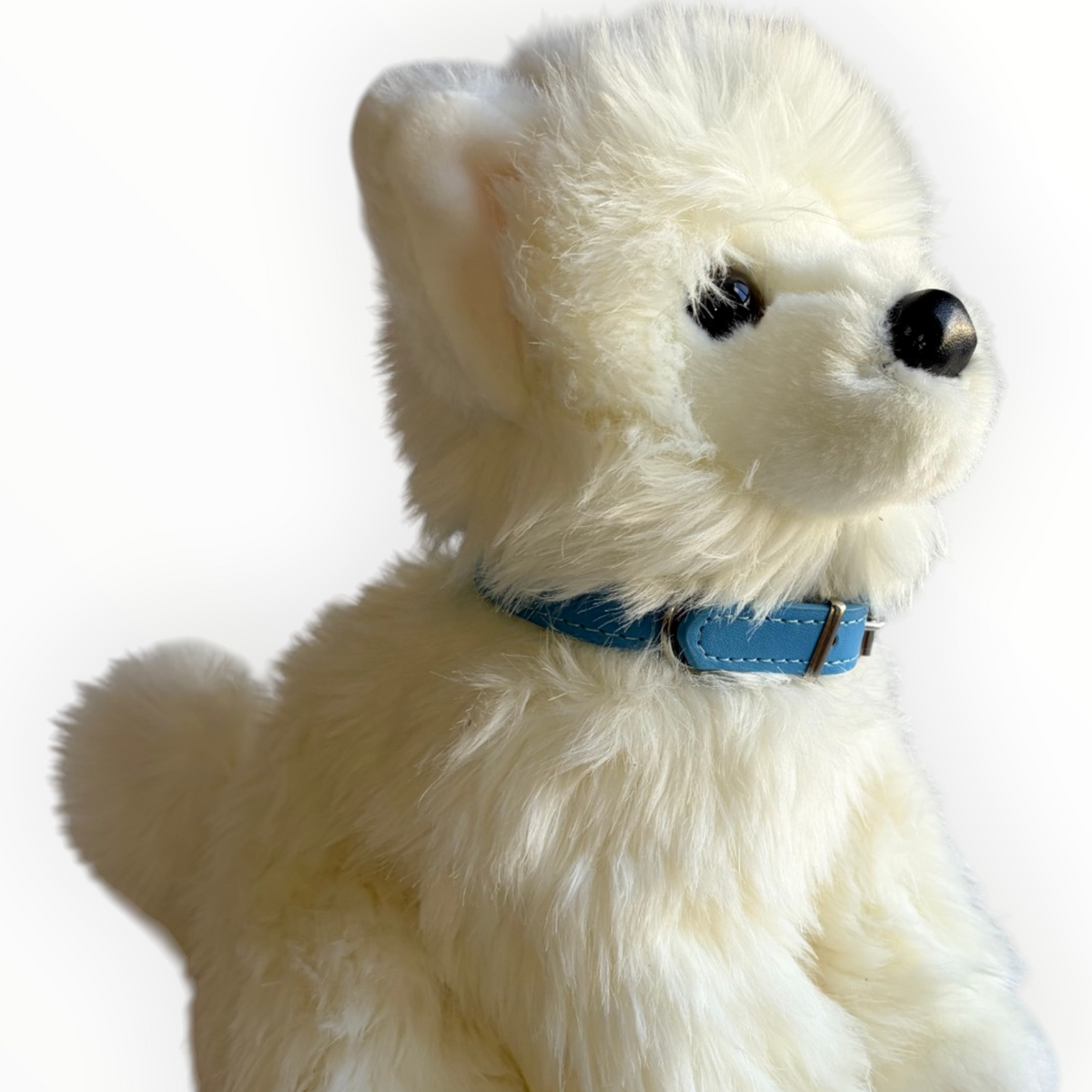 A fluffy white plush dog wearing a light blue collar, photographed against a plain white background.
