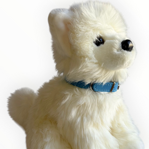 A fluffy white plush dog wearing a light blue collar, photographed against a plain white background.