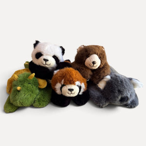 A group of four small plush animal toys arranged together on a light gray background: a panda, a red panda, a brown bear, and a gray wolf.