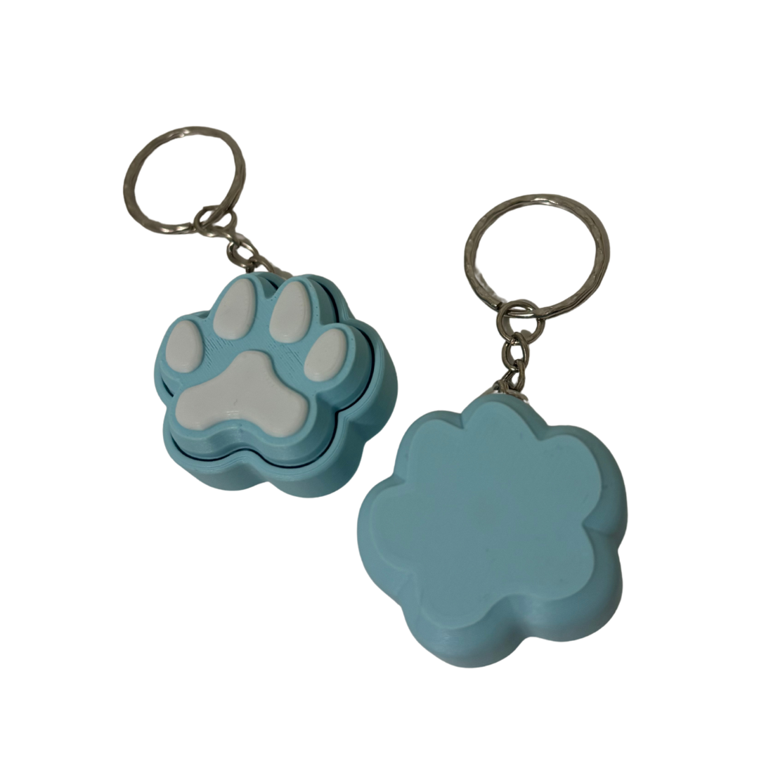 Two blue keychains with paw designs on a white background